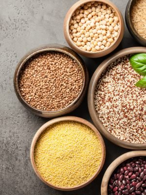 Set with various cereal grains and legumes on stone background